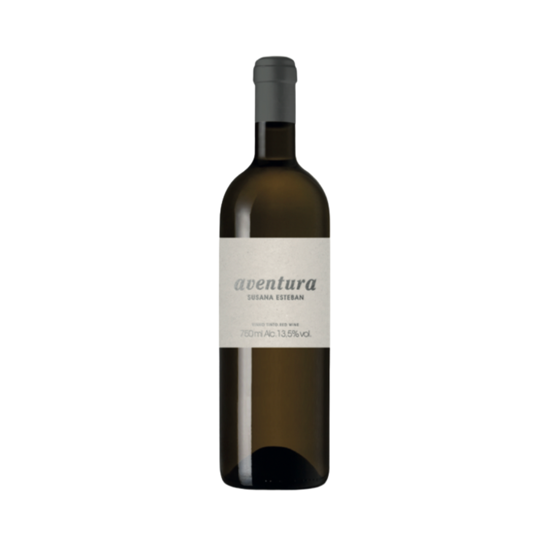 Bottle of Susana Esteban Aventura Branco 2023 with clean label and golden wine in a clear Burgundy-style bottle, set against a rustic background with stone and olive branches.
