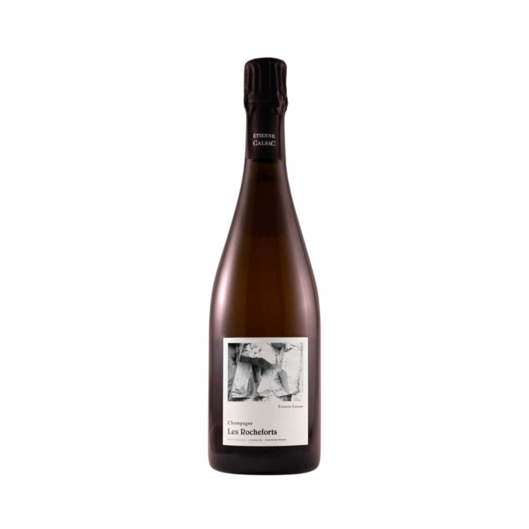 Bottle of Étienne Calsac Les Rocheforts 1er Cru Champagne on chalky vineyard slope at sunrise, reflecting its east-facing Chardonnay terroir in Bisseuil.

